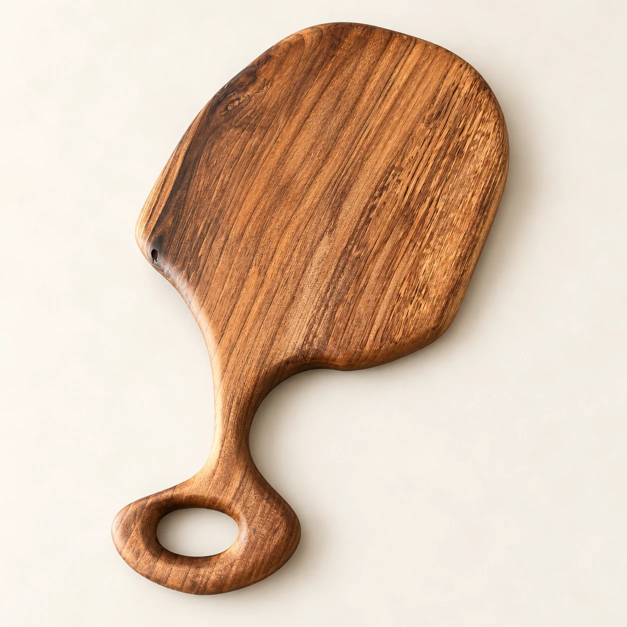 catalog view of the organic walnut paddle cutting board on a neutral background