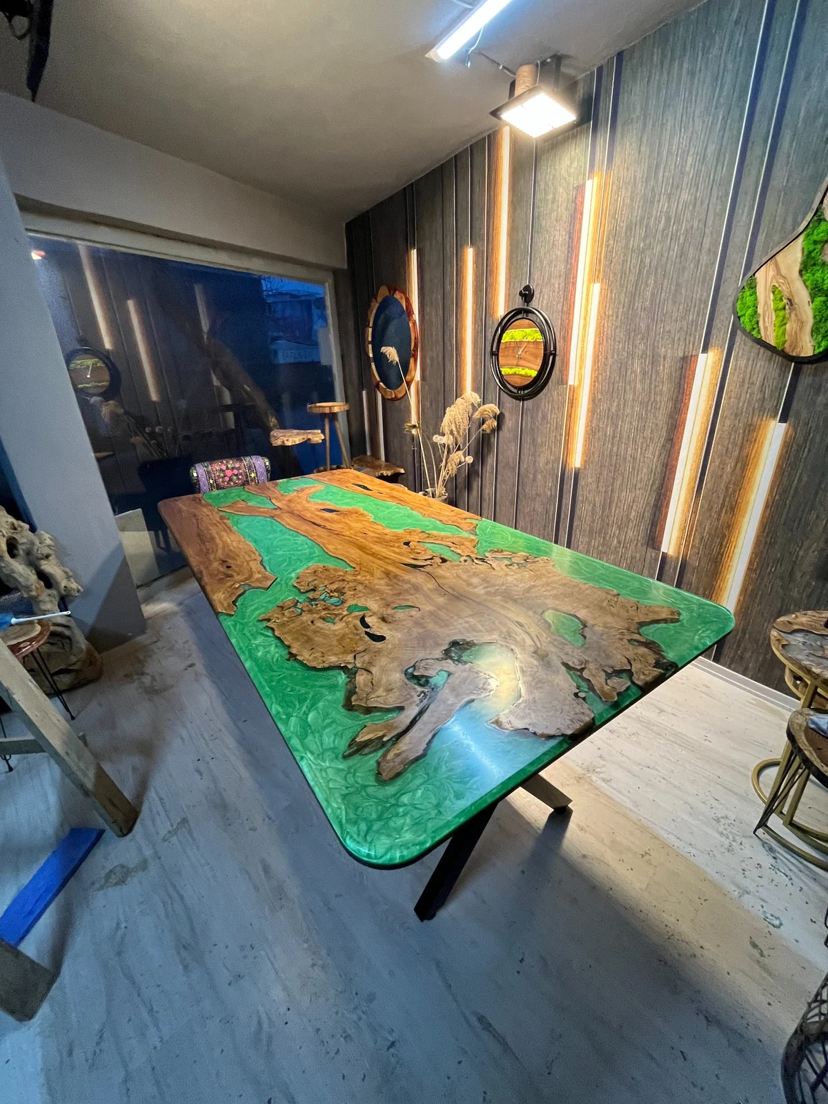 Full rectangular green resin and wood dining table viewed diagonally in the workshop
