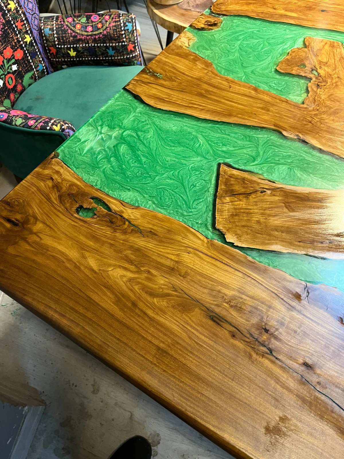 Pearlescent green resin swirls between irregular natural wood edges
