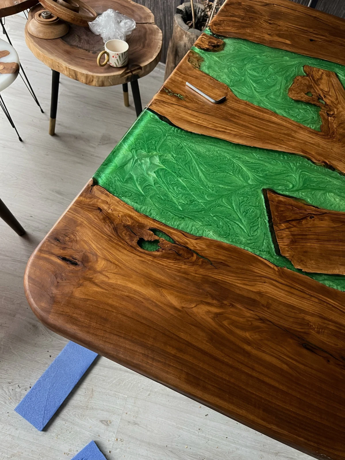 Rounded tabletop corner showing natural wood grain and green epoxy