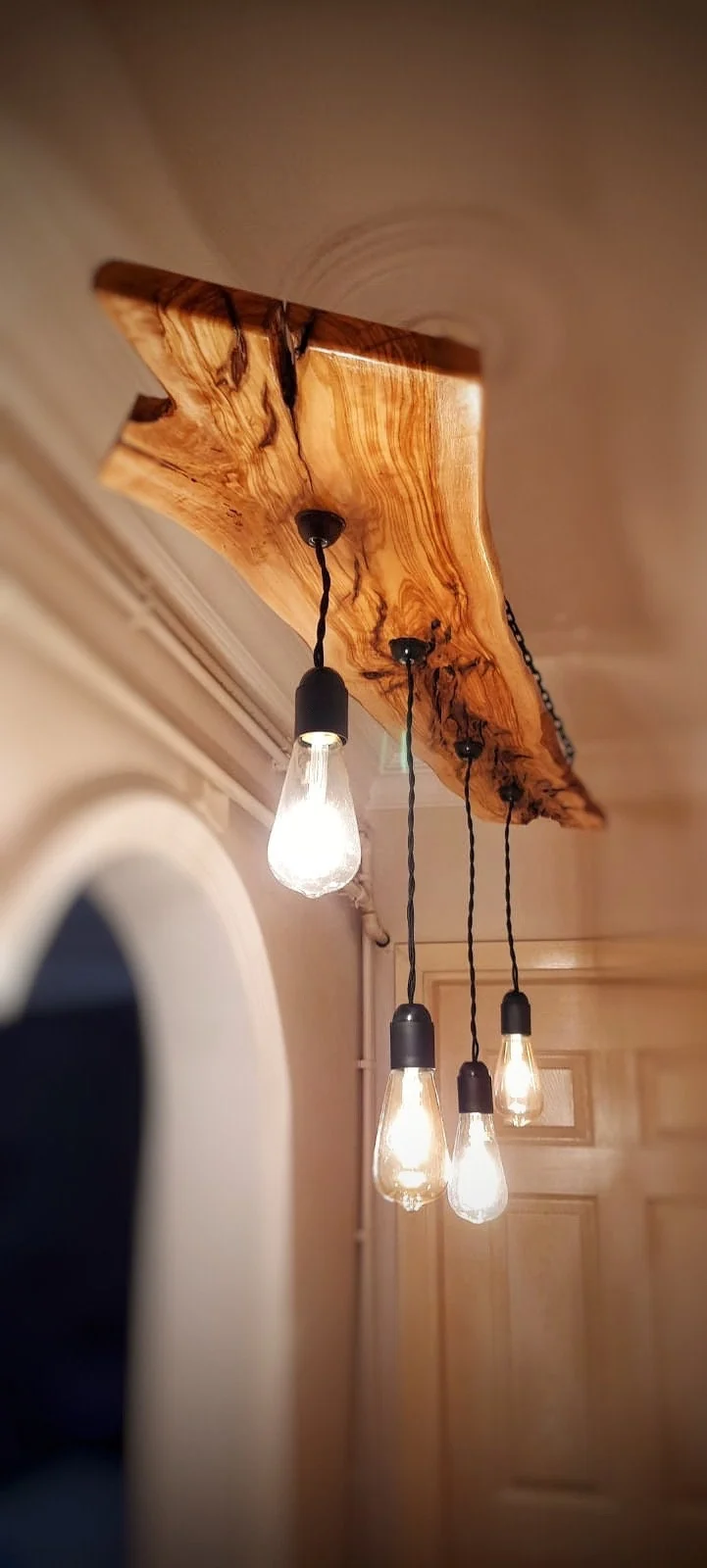 Original olive wood chandelier with four pendant bulbs on black twisted cords