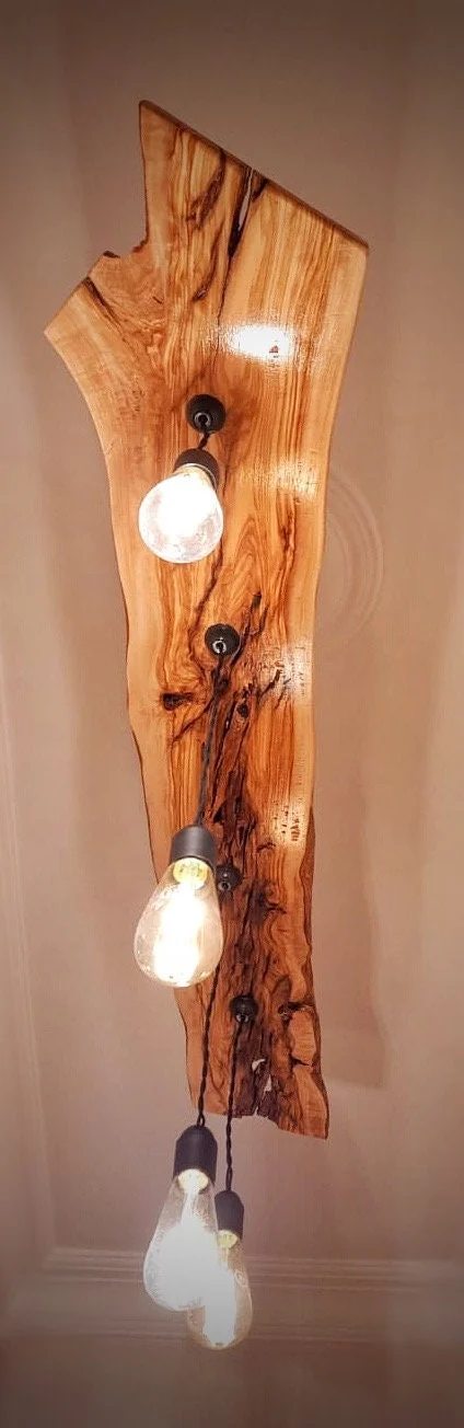 Underside of the real live edge olive wood chandelier showing grain and hanging bulbs