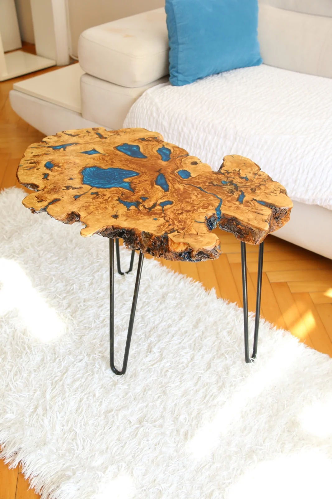 Asymmetric olive burl coffee tabletop with blue resin pockets and natural edge
