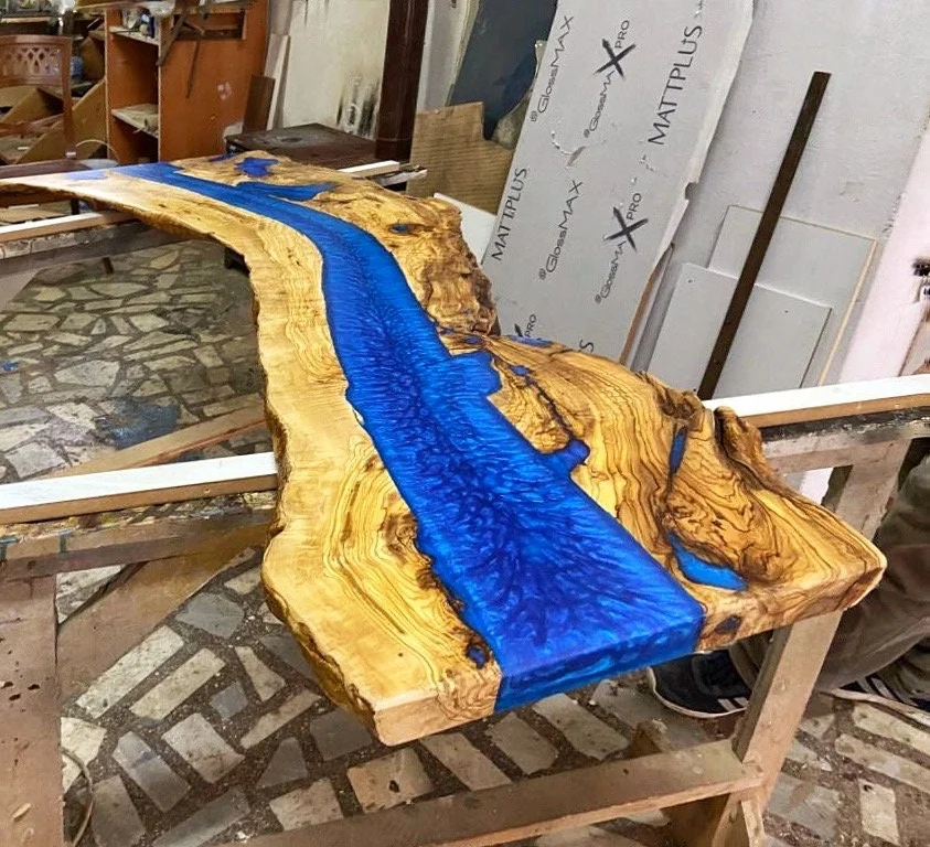 Overhead workshop view of the curved olive wood and blue resin slab
