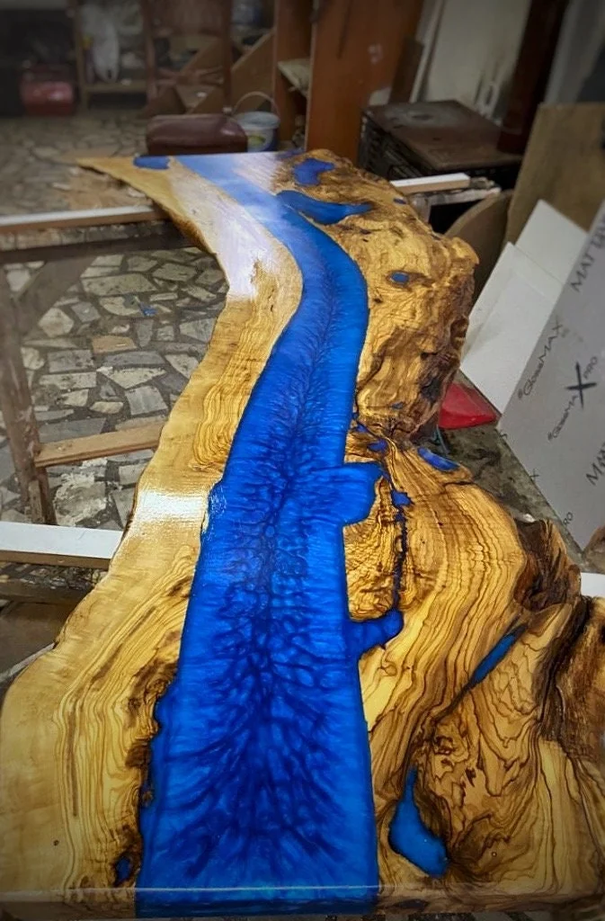 Lengthwise view of the olive wood slab and flowing blue resin channel