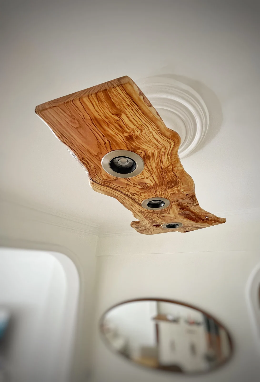 Live edge olive wood ceiling fixture viewed from below in an interior