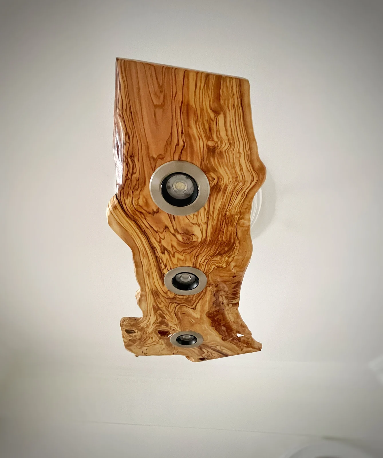 Olive wood ceiling light showing its natural outline and recessed light positions