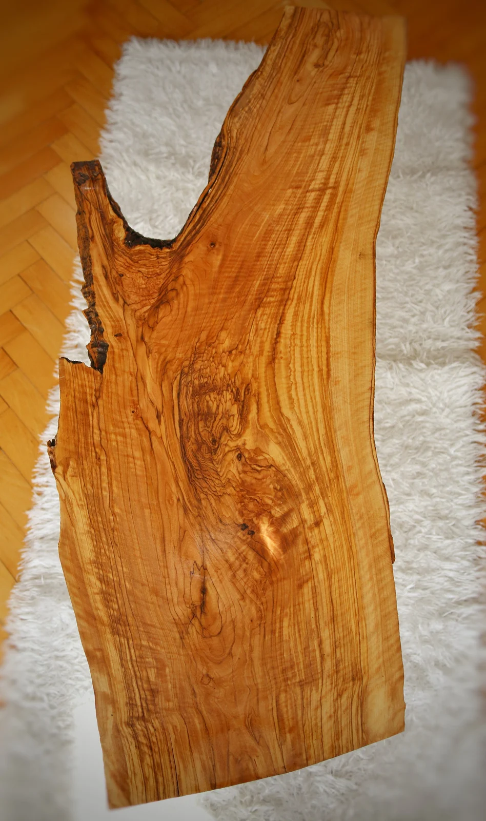 Top view of the olive wood slab showing flowing grain and a natural opening