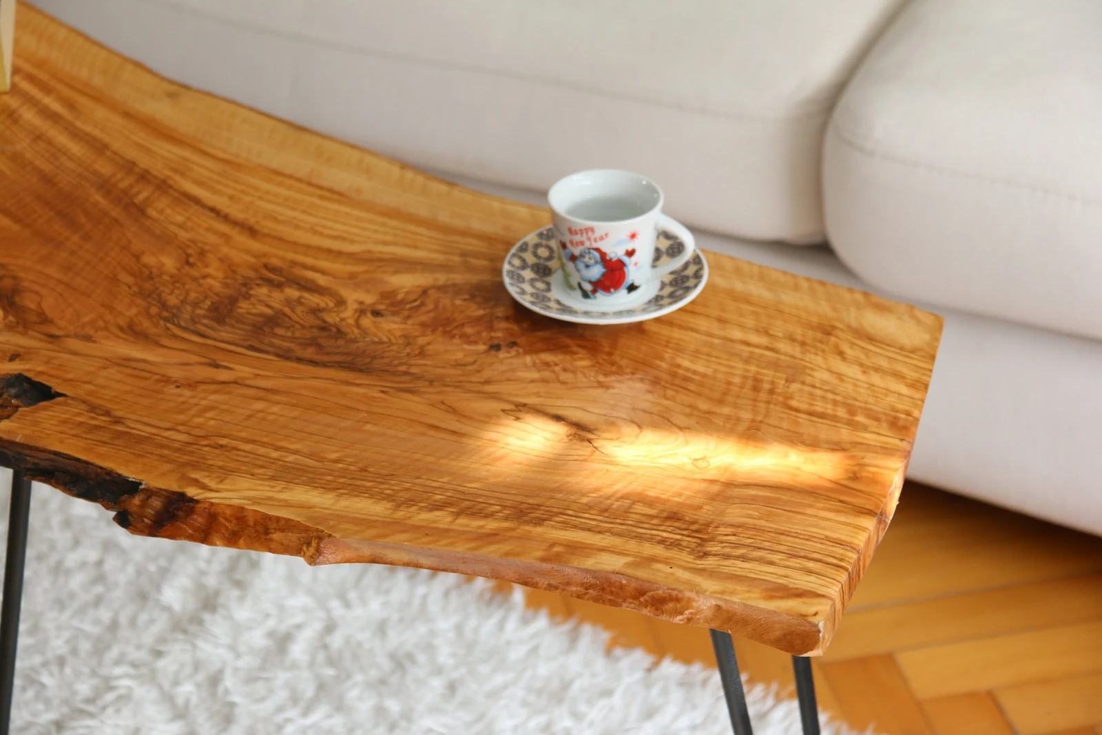 Close-up of the olive wood grain and natural edge with a coffee cup