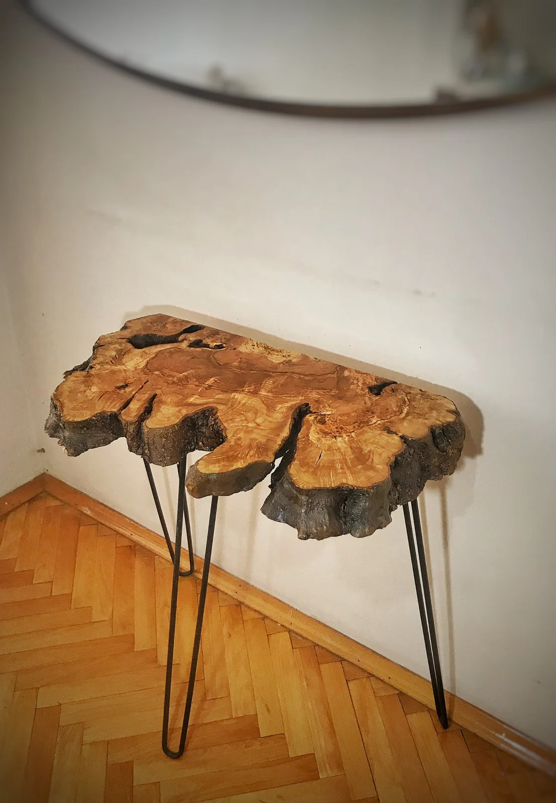 Olive wood live edge console table with black hairpin legs against an entryway wall