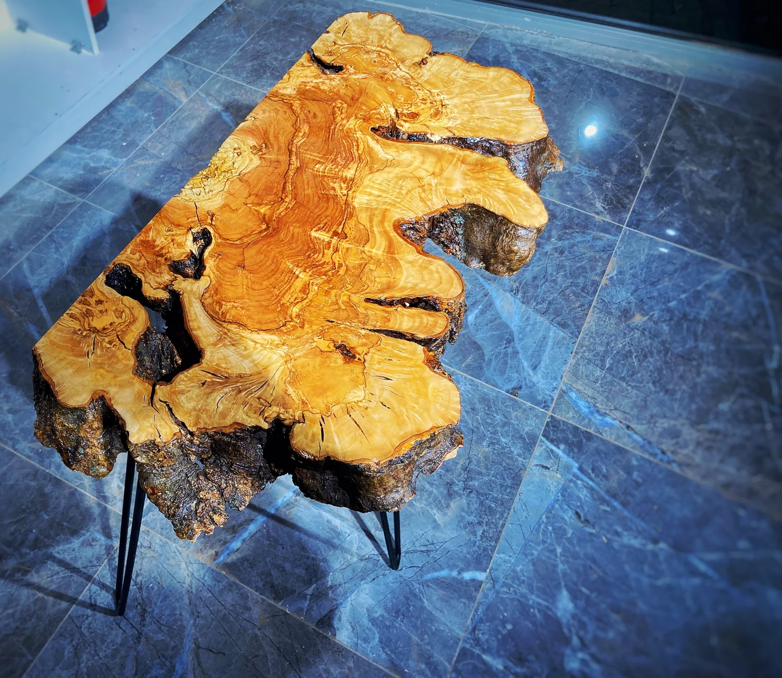 Angled view of the organic olive wood console tabletop and its natural edge