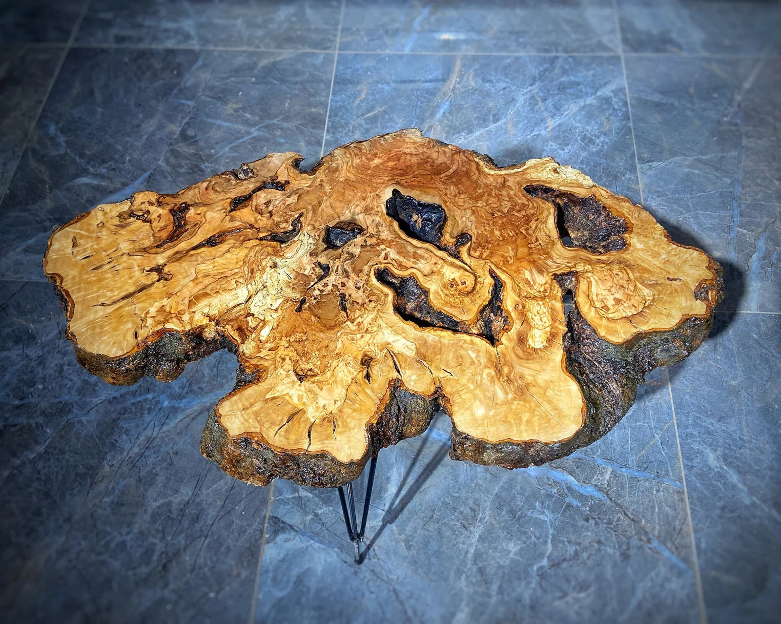 Top view of the olive wood coffee table showing flowing grain and irregular edges