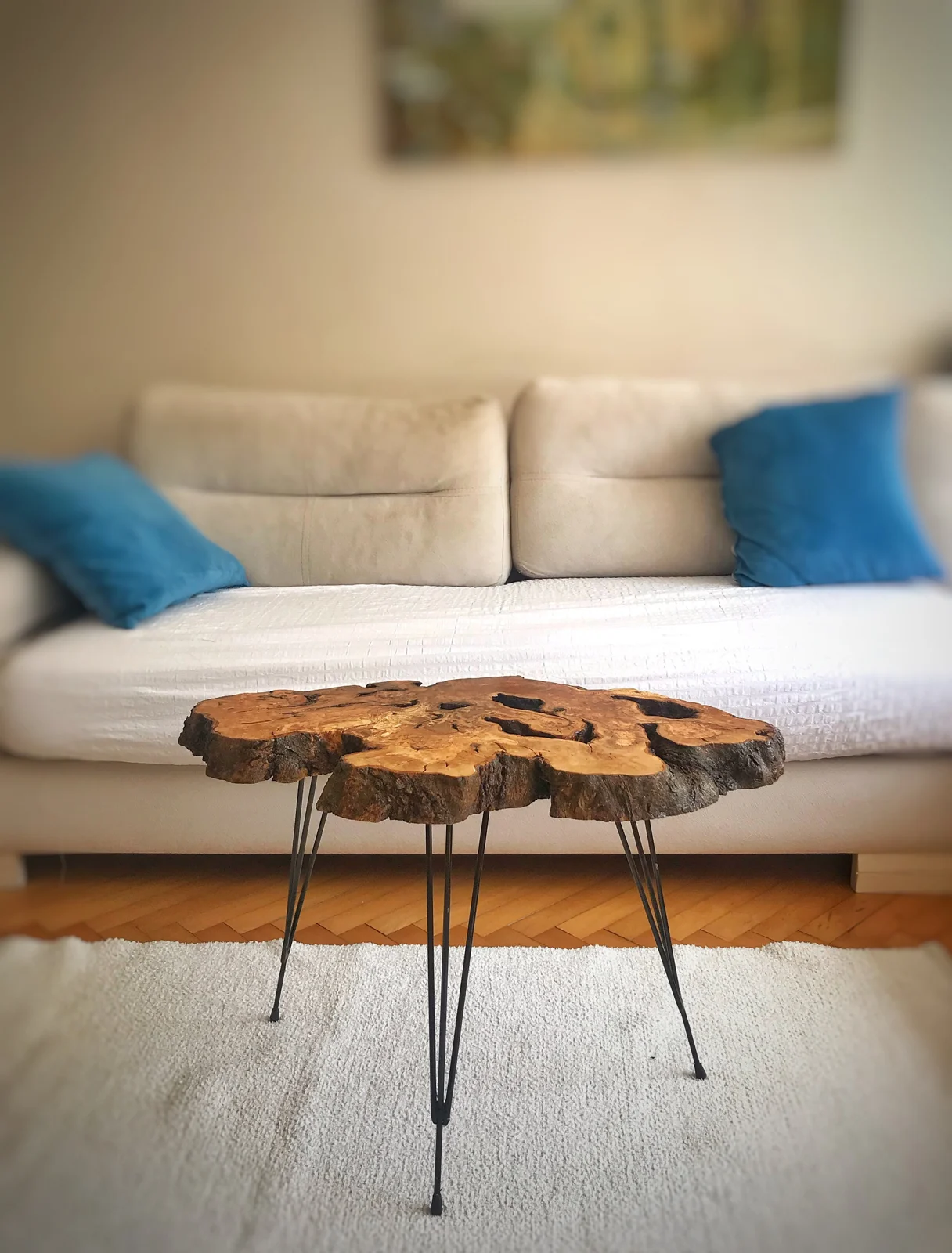 Olive wood live edge coffee table shown without accessories in a living room