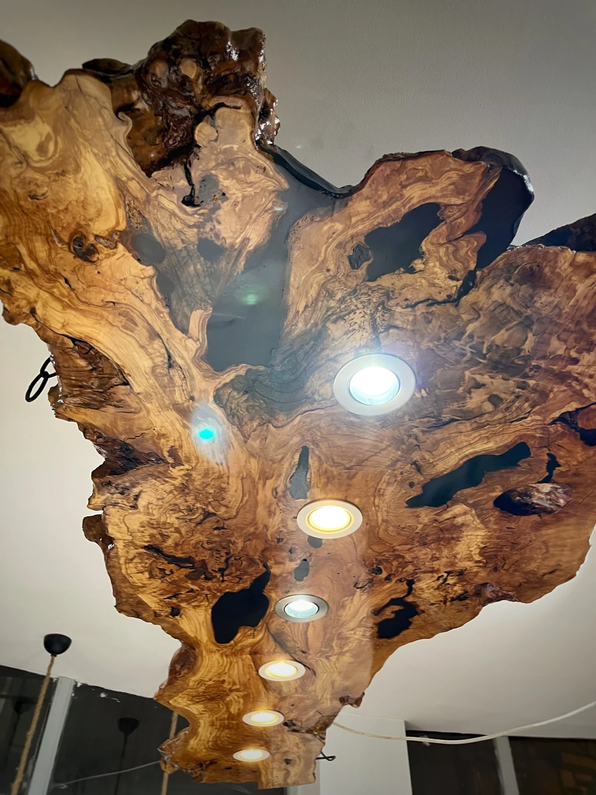 Original close-up of wood grain, dark openings and recessed spotlight rings