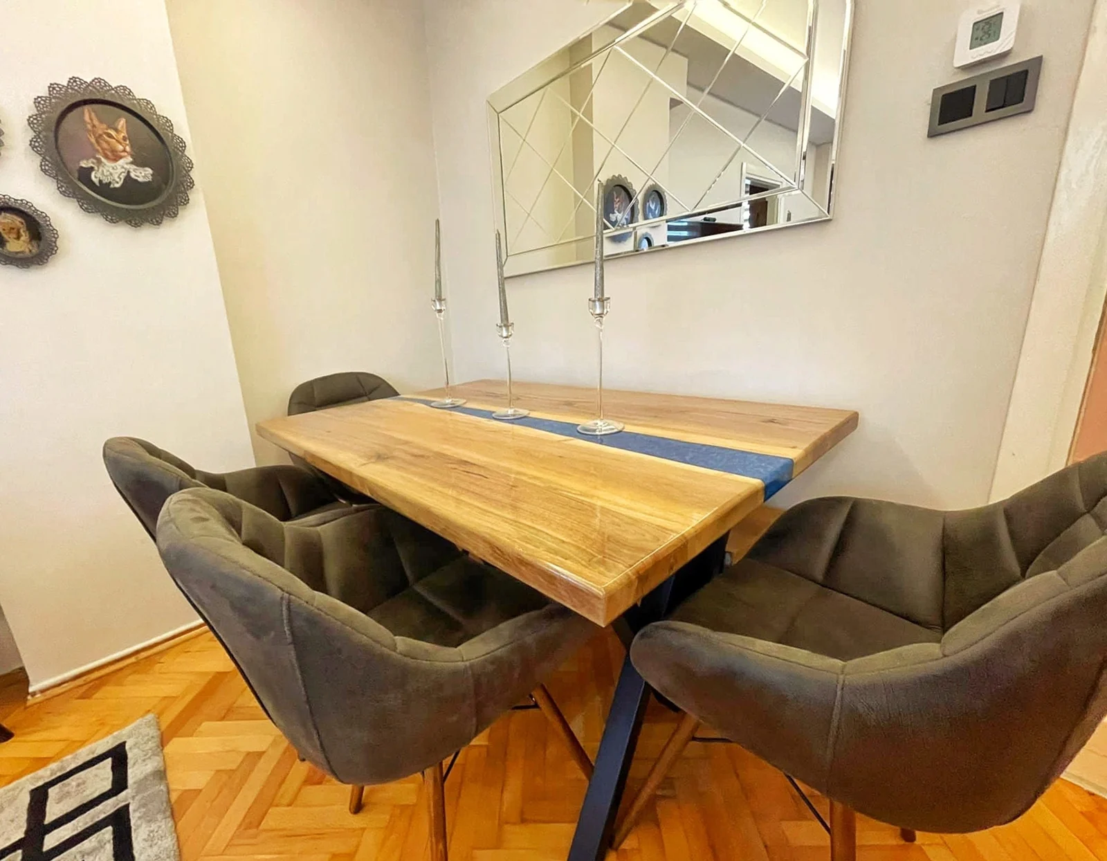 Original blue epoxy river dining table shown with upholstered chairs