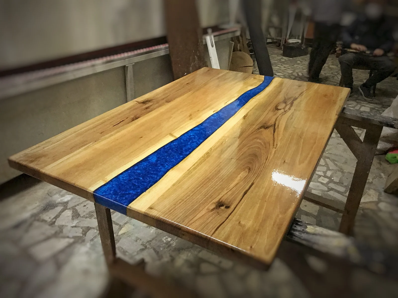 Angled workshop photograph of the wood slab and blue epoxy river