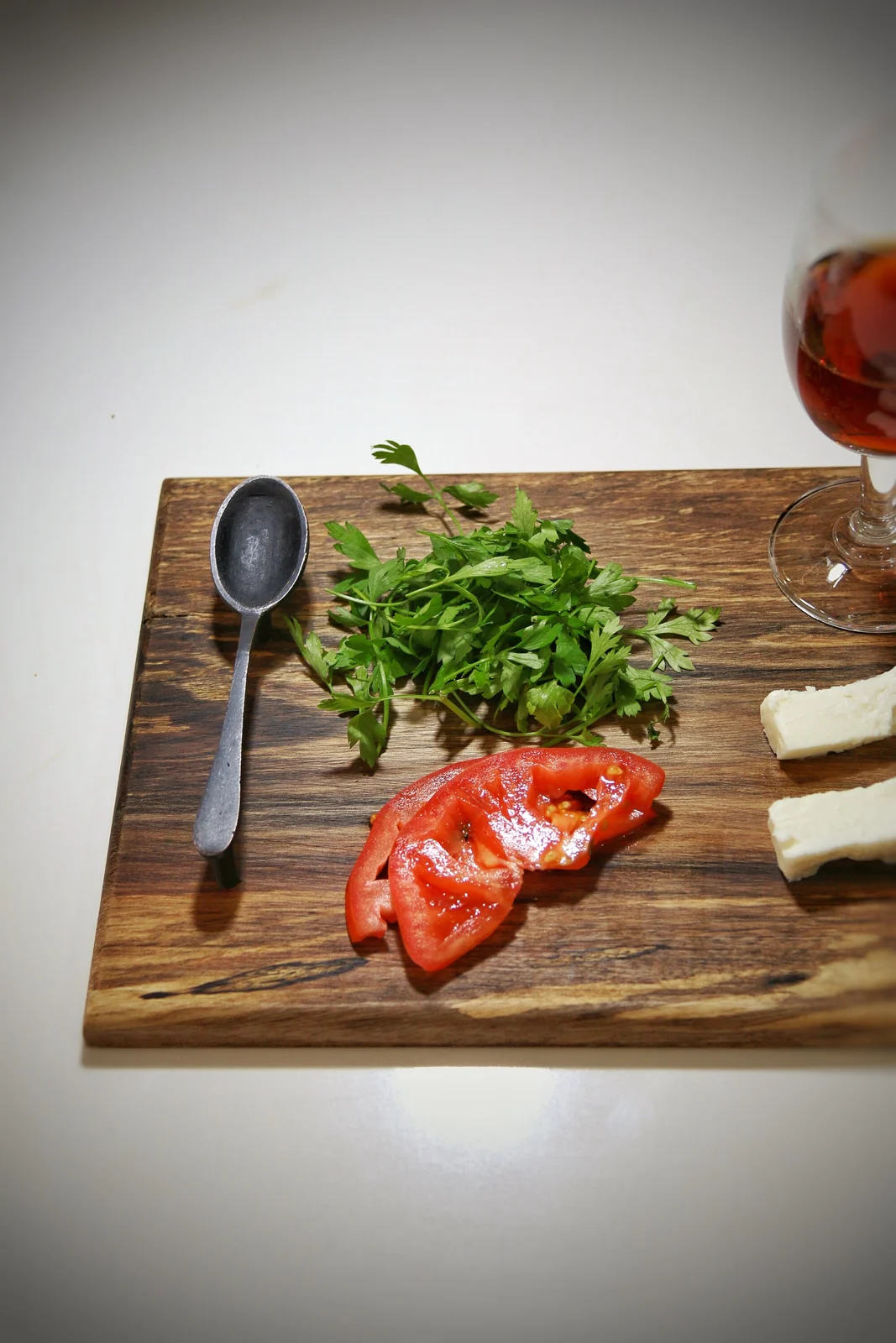 Close-up of walnut grain on a serving board with tomatoes and cutlery